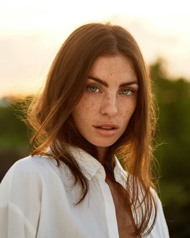 a portrait of a person transformed to wear a T-shirt with a clear illustrated graphic of a simple line-art object such as a flower, star, or abstract face, drawn with thin black outlines, flat illustration style, no background texture inside the print, centered on the chest, with crisp edges, realistic print contrast, natural fabric folds, and consistent lighting