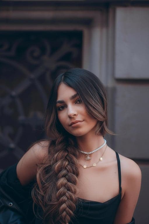 a fishtail braid with intricate sections, loosely woven for volume and texture, with natural-looking separation between the strands, and a polished finish that enhances the overall texture