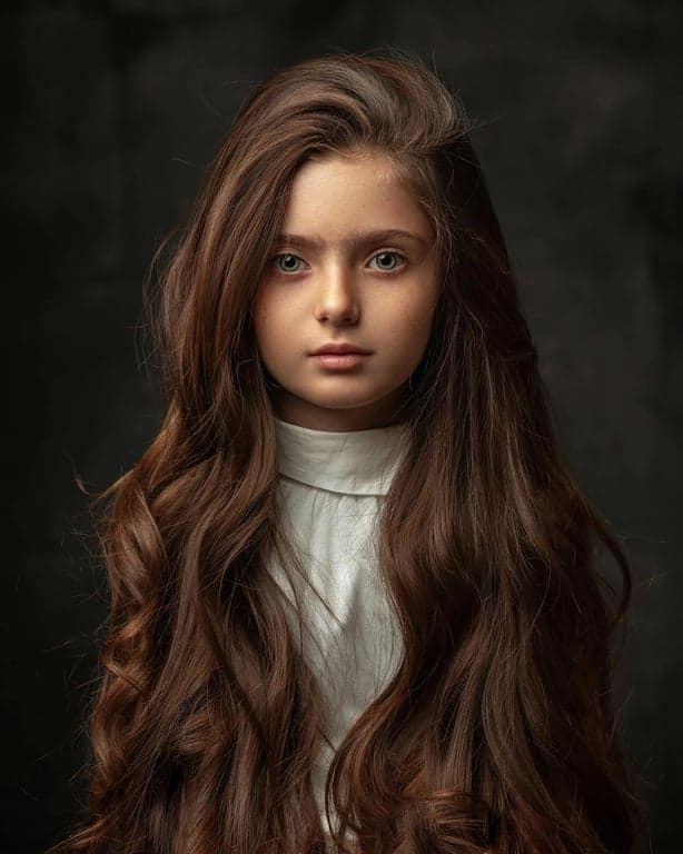 a portrait of a person transformed into a Demon Slayer–inspired anime illustration with strong ink-style outlines, intense facial expression, traditional anime clothing with layered fabric, dynamic lighting, and cinematic shadows