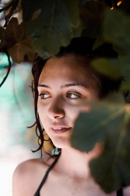 a portrait of a person refined by selectively cleaning chaotic light artifacts, keeping soft face light intact and restoring clear, readable facial detail