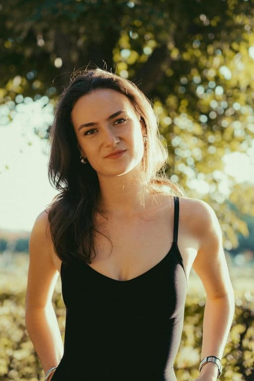 a portrait of a person transformed by dramatically lowering the hairline, filling in the upper forehead area so the hair coverage extends downward and creates a denser, fuller hair appearance that reduces face size