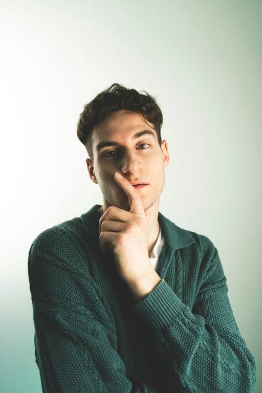 a portrait of a man edited in a Korean side-swept men hairstyle style, so that the top hair is straight and brushed to one side, with the fringe covering one side of the forehead as seen in Korean men styling, the opposite side and back trimmed short and straight, no curls or waves, and unchanged face and original lighting