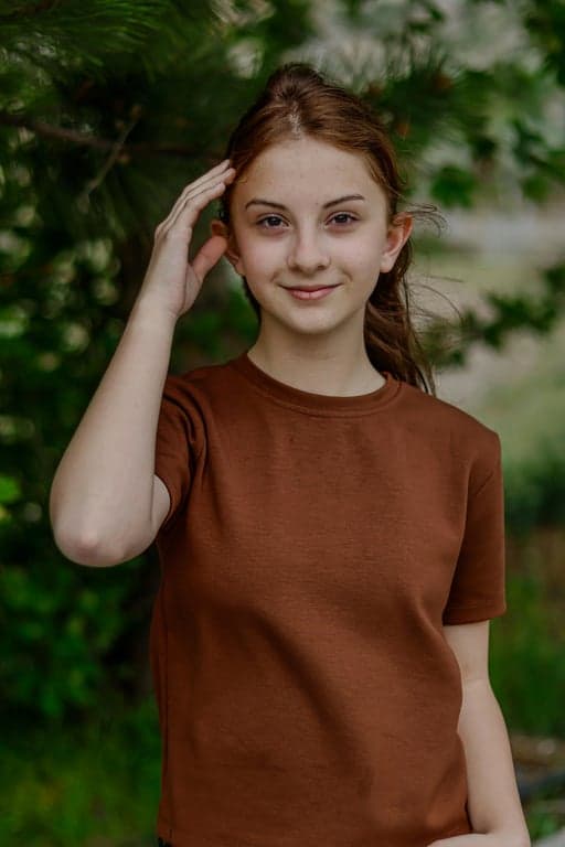 a portrait of a person reimagined as a magical girl during transformation, featuring a clean magical outfit with fitted bodice, short skirt, glowing brooch, flowing ribbons, magical energy rings, and expressive anime aesthetics