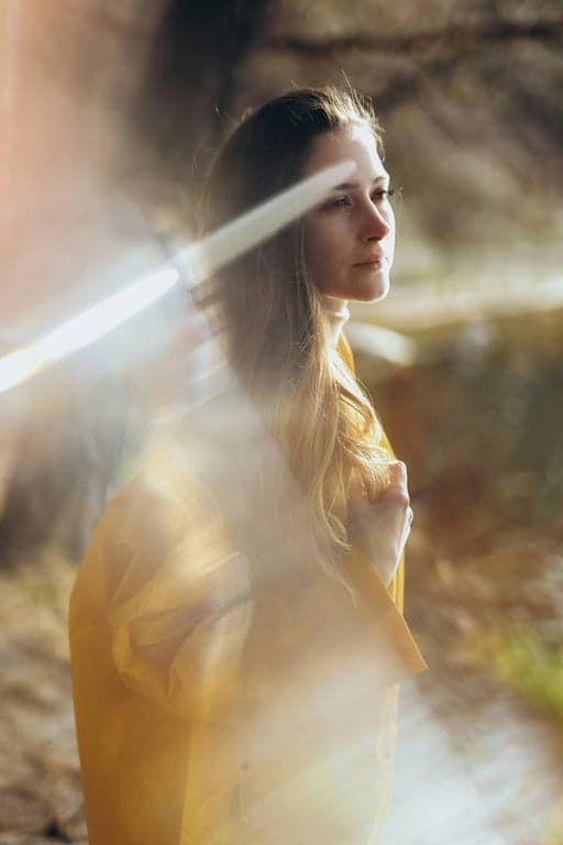 a portrait of a person processed to remove only non-natural light artifacts such as lens flare spots, streaks, and chaotic shadows, while keeping intentional facial lighting, realistic depth, and natural skin texture