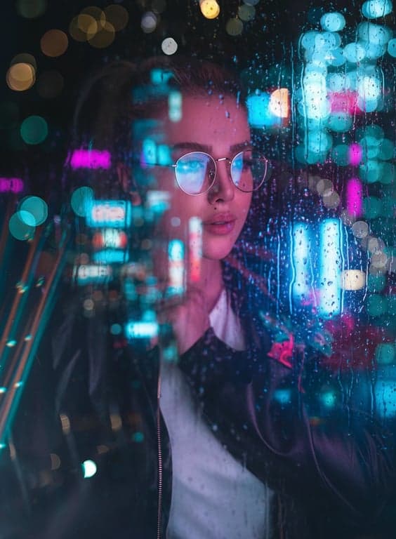 a portrait of a woman in a cyberpunk cinematic style, featuring neon glow, rain-streaked windows, and futuristic city reflections