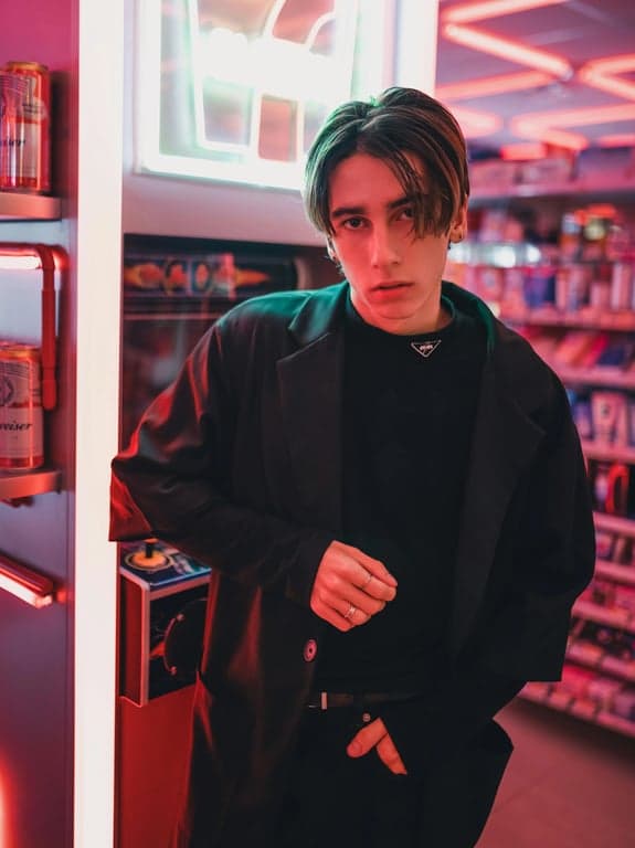 batman standing on a gargoyle, dark knight cinematic style, rain-soaked cape, neon-lit gotham city below, low-angle shot.