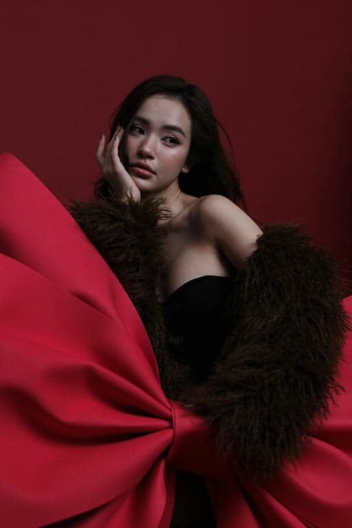 Transform the original person into a Hello Kitty parallel world 3D toy figure with a cat face. Preserve pose and outfit structure, render the character as a smooth plastic collectible with an oversized head, tiny body, glossy surfaces, minimal facial detail, and soft pastel colors.