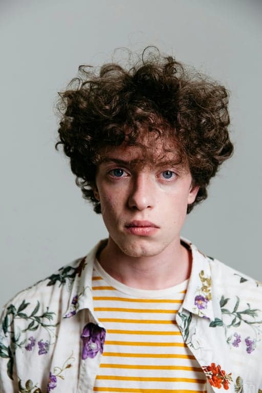 a portrait of a person illustrated in a modern shonen anime style inspired by My Hero Academia, emphasizing hero symbolism, expressive posture, crisp linework, and cinematic anime lighting