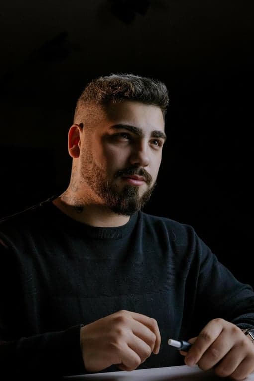 a portrait of a person edited to change the face shape from a round or wide appearance into a sharp V-shaped face, significantly narrowing the jaw and lower cheeks, pulling both sides inward to form a pointed chin shape, keeping forehead width unchanged, eyes nose and mouth in the same position, with a clearly visible before-and-after difference