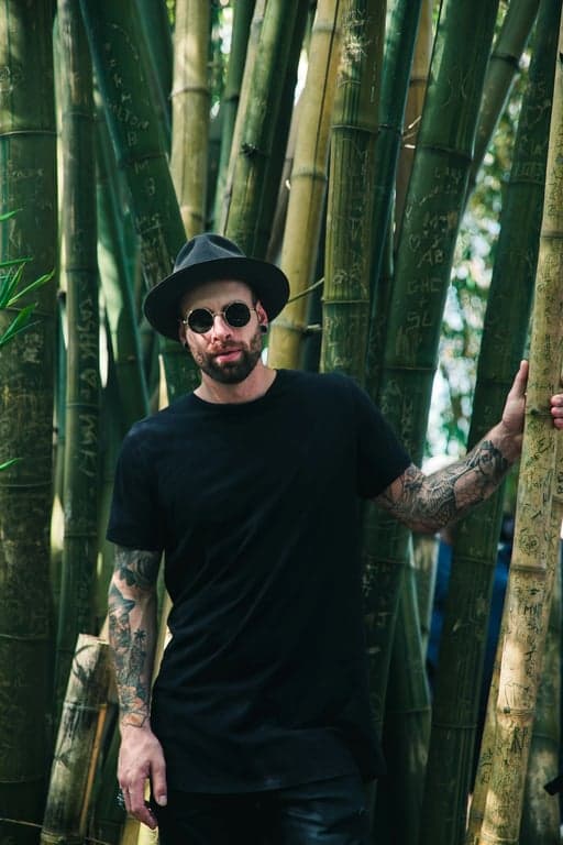 A realistic edited portrait of a man, detailed skin retouching that preserves pores and texture, natural teeth whitening, subtle eye enhancement, realistic color grading, studio backdrop.