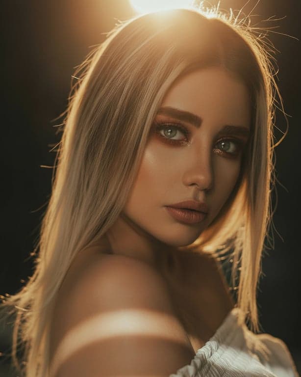 A backlit portrait where the sun is strategically placed behind the subject's head to create a glowing hair light effect and a soft, ethereal silhouette.