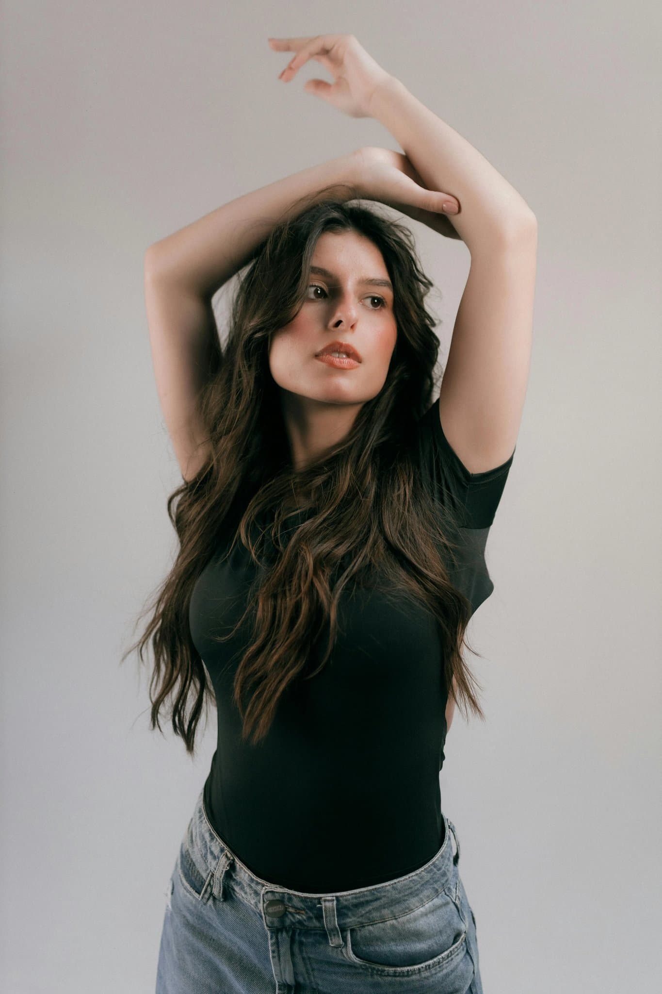 A full-body photo of a young woman wearing casual jeans and a t-shirt.