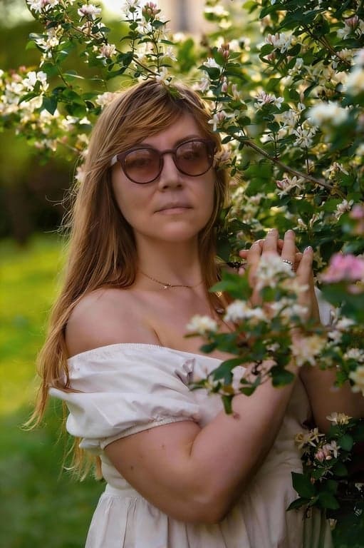 a portrait of a person edited to significantly slim the chin and under-jaw area by reducing submental fullness and carving a clearer jaw-to-neck boundary; visually lift the chin area to remove heaviness; keep jaw width and chin projection realistic; preserve natural skin texture and tone; avoid stretched or pulled neck artifacts; keep background completely unchanged; the result should show an obvious reduction of double chin while remaining believable