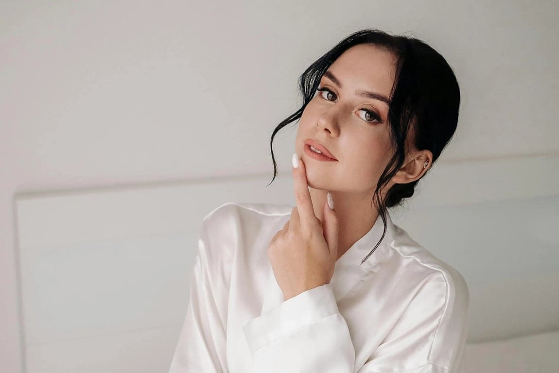 a portrait of a person edited to move the hairline forward in a clear and aggressive way, filling sparse frontal areas so the hair starts lower on the forehead and creates a thicker, more youthful hair frame