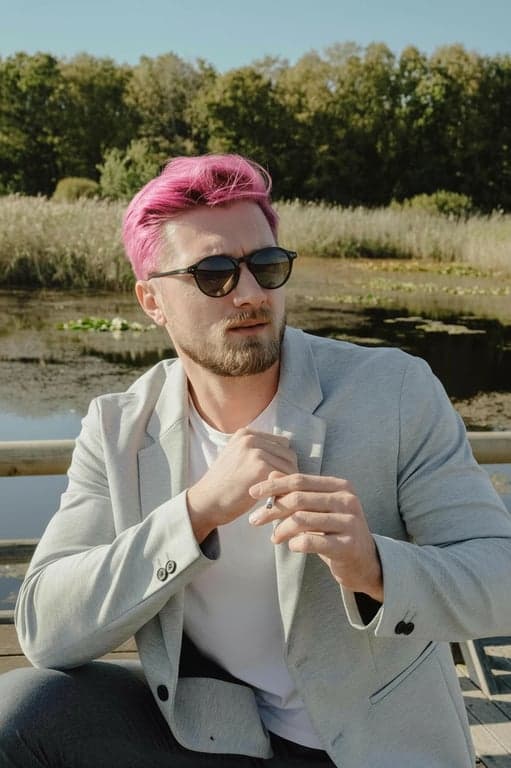 a portrait of a person styled with vivid pink hair, showing stronger saturation on mid-lengths, softer tone near roots, accurate hair volume, and realistic light reflection