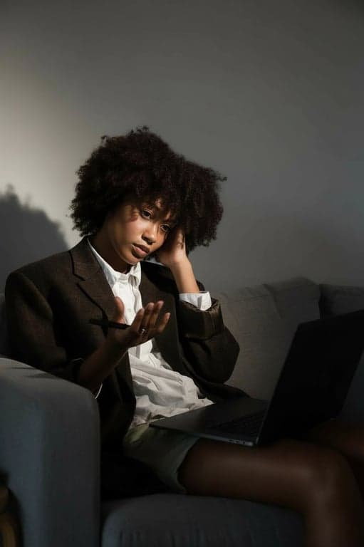 A high-end editorial portrait of a woman, detailed skin retouching that preserves texture, enhanced clothing details, dramatic shadow play, sophisticated color toning, studio backdrop.