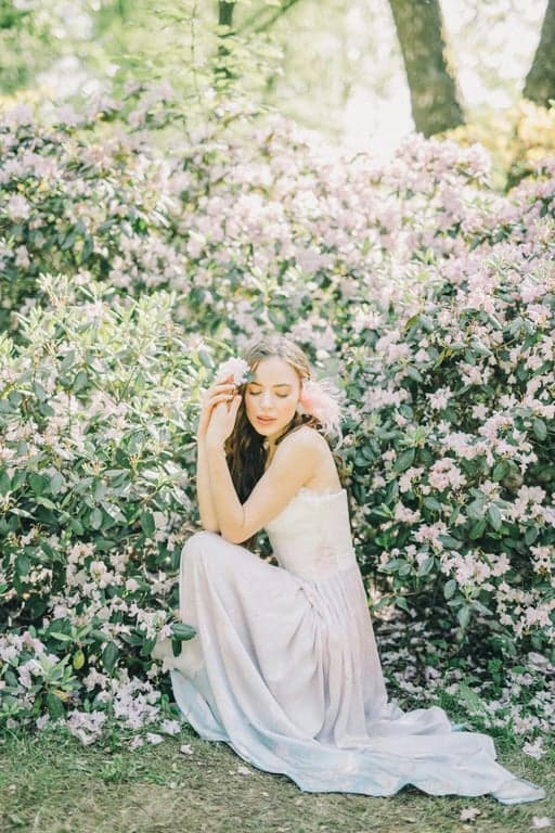 Reimagine the original person as a human character appearing alongside Hello Kitty in a 2D animated TV scene. Preserve pose and gesture, simplify the character into flat pastel animation style, and place both characters in a gentle story setting such as a kitchen, classroom, or park that matches Sanrio animation proportions.