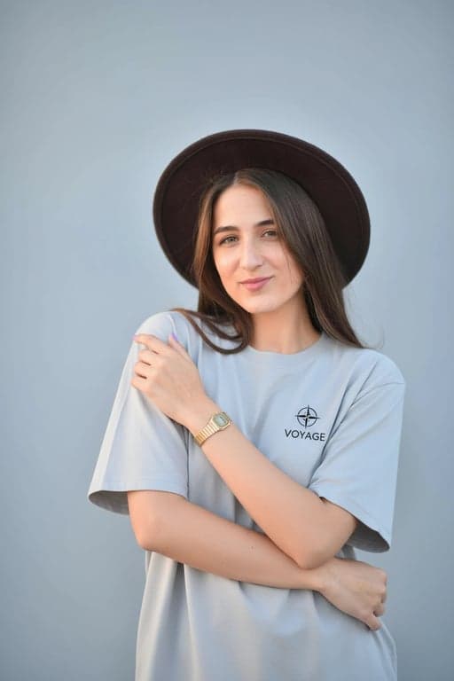 a portrait of a person transformed into a realistic T-shirt mockup with a simple logo-style design consisting of a small icon and short brand-like text beneath it, monochrome or two-color palette, clean vector-style edges, properly scaled to the chest area, and believable fabric behavior