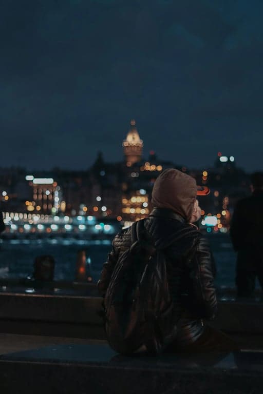 a portrait of a person transformed into a masked spider hero close-up, wearing a full spider mask with large white eye lenses, tight framing, strong contrast lighting, subtle comic shading, and a focused heroic expression conveyed through pose and lighting