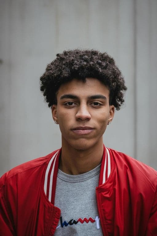 A realistically enhanced portrait of a man, object removal from background, realistic shadow adjustment, noise reduction, sharpness enhancement, natural skin tone preservation.