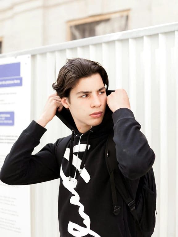 A pixel art sprite (64x64) of a fierce fire-type pokemon in a dynamic battle pose, mid-leap towards its opponent. In the background, the pixelated silhouette of its determined trainer is visible, giving a command.