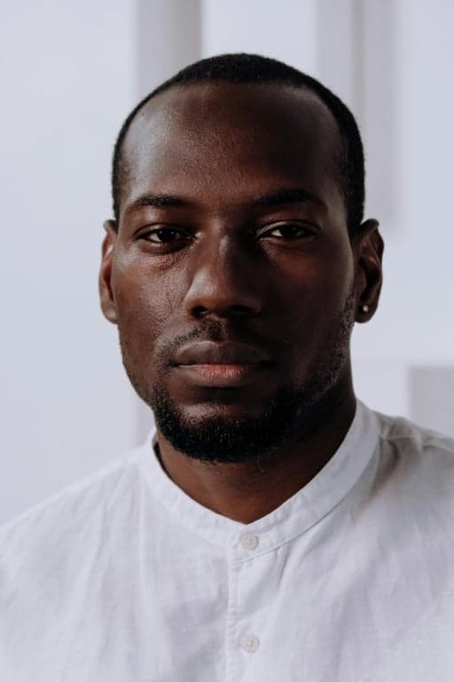 a portrait of a man, official passport photo, plain white background, neutral expression, full face view, even frontal lighting.