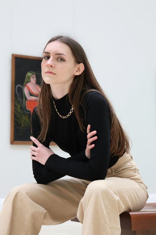 a portrait of a person stylized in an American Gothic art style featuring stiff formality, controlled color palette, realistic but simplified facial detail, and solemn rural mood