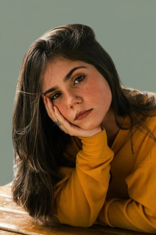 a portrait with the background replaced by a muted green-gray tone, providing a neutral yet distinctive and modern backdrop