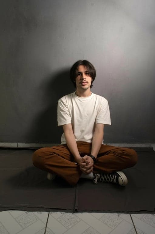 a portrait of a man edited in a Korean men fringe haircut style, so that the top hair is medium length and straight, with the front hair forming a visible uneven fringe covering part of the forehead in a typical Korean textured fringe look, sides and back shorter and straight, no waves or curls, and unchanged face and original lighting