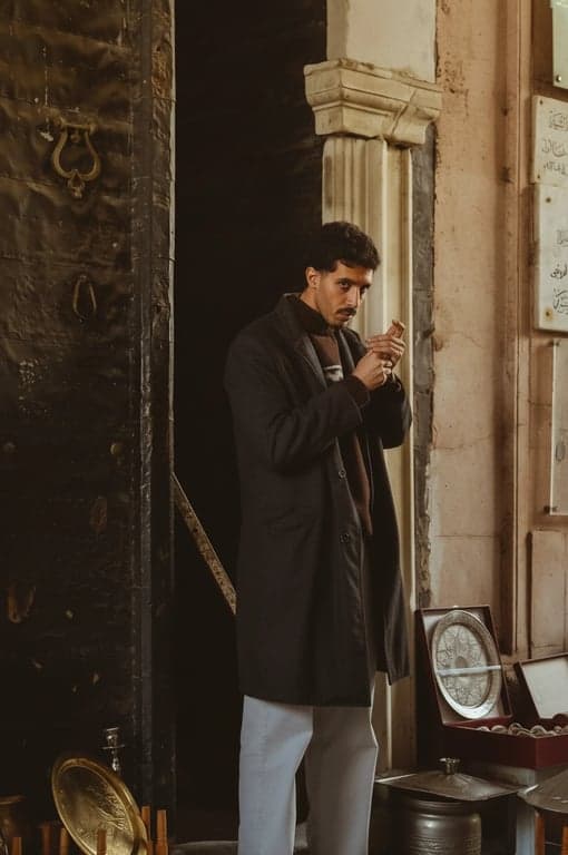 a portrait of a man, dramatic editorial conversion, chiaroscuro lighting, intense gaze, textured background, cinematic quality.