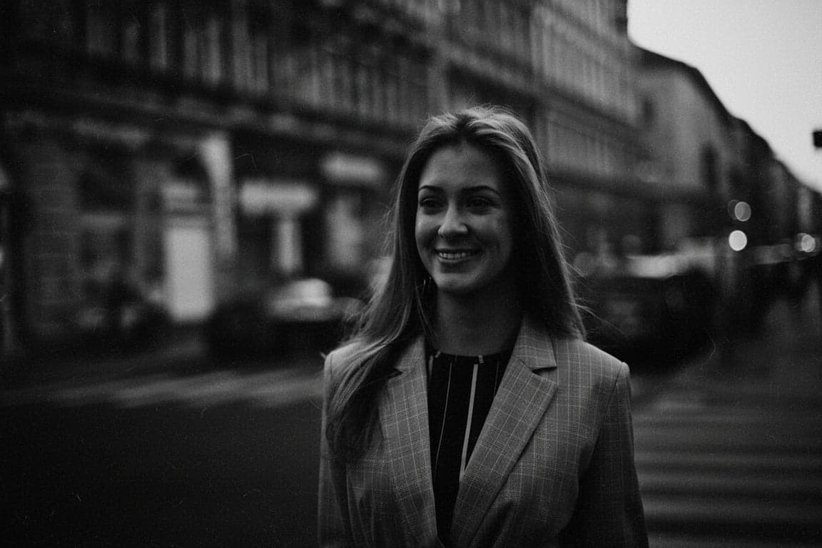 A black and white portrait with a 60s film noir influence, featuring high contrast, dramatic shadows, and a moody, cinematic atmosphere.