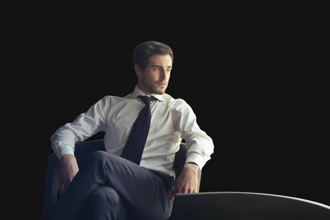 a portrait of a man with the background changed to a solid deep charcoal black, adding a dramatic and intense mood to the image