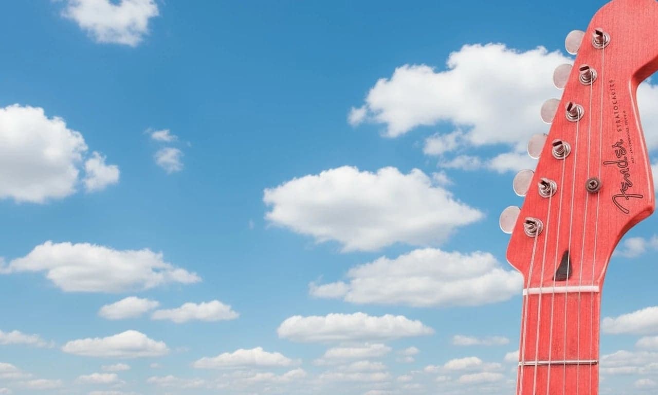 AI green screen remover after photo - red guitar model isolated on blue sky background