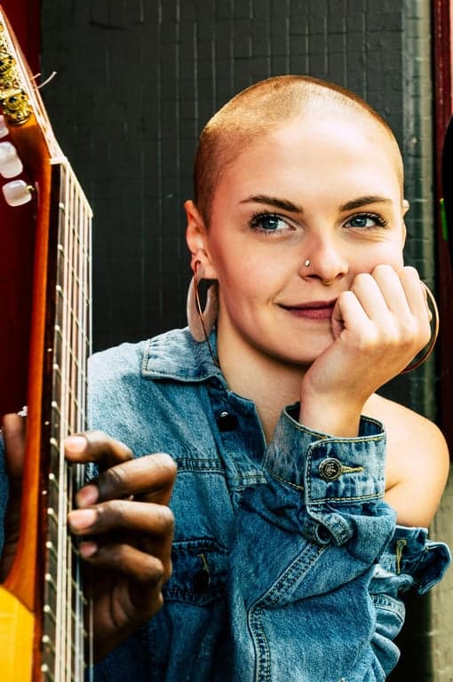 a portrait of a person with hair volume boosted through texture-aware density enhancement, focusing on crown and upper sections; maintain original hairstyle structure and direction; preserve natural flyaways and strand variation; avoid smooth plastic surfaces or exaggerated fluffiness; do not modify face, body, or background; final result should read as naturally fuller hair