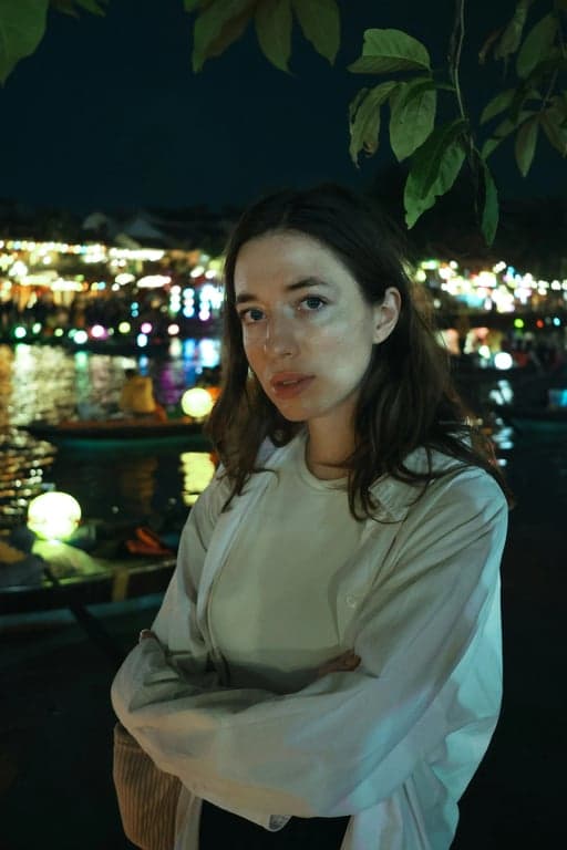 A cinematic headshot of a woman, with a teal color cast in the midtones and vibrant orange highlights, chiaroscuro lighting effect, filmic texture, neutral environment.