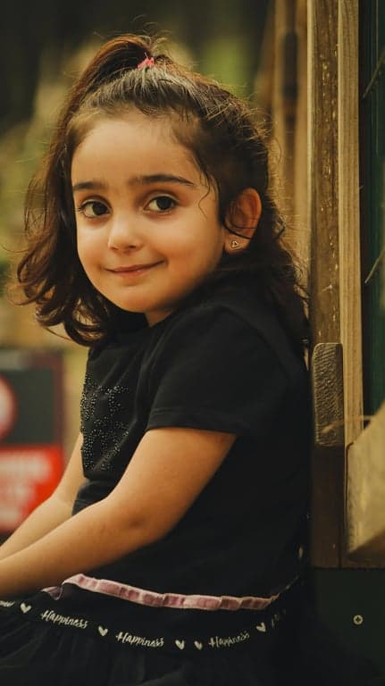 a portrait of a person styled as a magical girl mid-transformation, wearing a form-fitting magical dress with sailor collar, ribbon bow, pleated skirt, glowing accessories, wrist guards, knee-high boots, luminous highlights, and vibrant anime colors