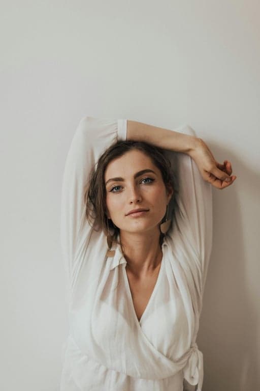 A studio portrait emulating the clean, minimalist style of 1960s corporate or yearbook photography, with even lighting, a neutral grey backdrop, and a sincere expression.