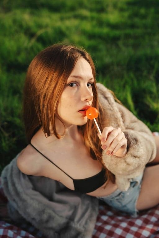 a portrait of a woman in an ordinary setting edited to have golden hour sunlight, with long shadows, warm orange tones, and a soft hazy glow from the side.