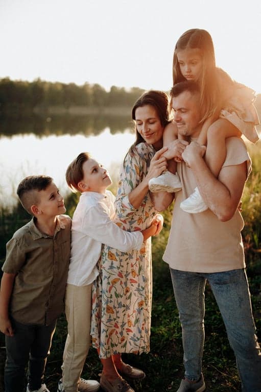 a portrait of a family transformed into a formal studio family portrait, all members wearing elegant coordinated formal outfits such as suits and dresses in neutral tones, posed upright in a clean studio environment with professional lighting, balanced composition, and confident, composed expressions