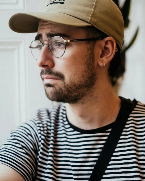 generate a sad facial expression by clearly reshaping key facial features including eyebrows, eyes, and mouth, prioritizing instant emotional readability over realism