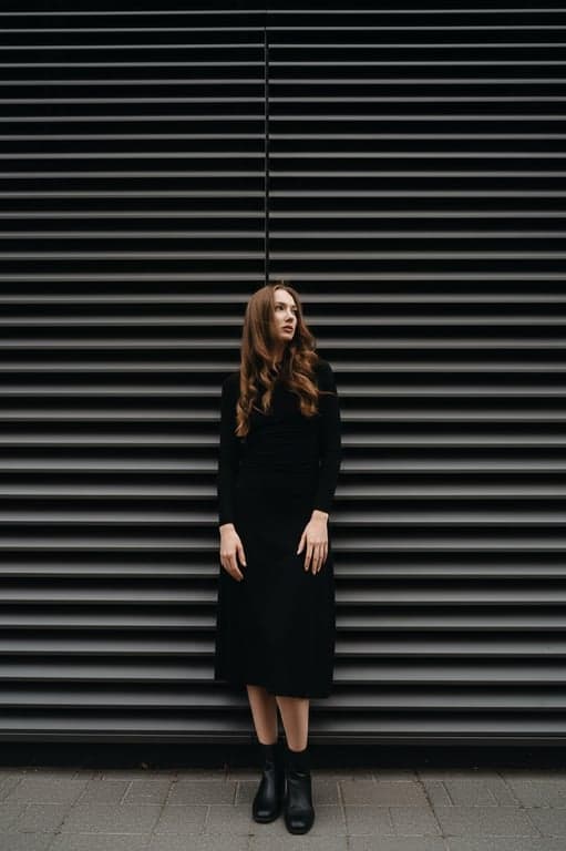 Complete the full-body view of the person by extending the image downward while keeping lighting direction, exposure, and perspective consistent from head to toe. Ensure hands, legs, and feet are anatomically correct and visually connected to the original upper body.