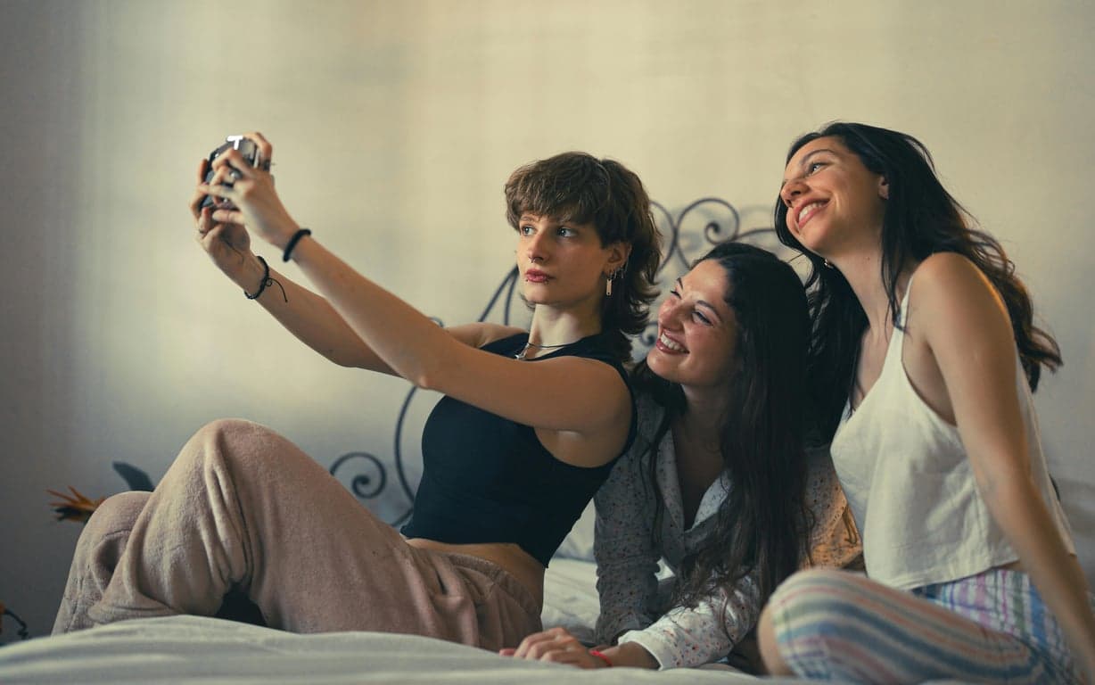 The letter "E" is formed by the silhouettes of three people: one jumping (top line), one running (middle line), and one crouching (bottom line), in a dynamic black silhouette.